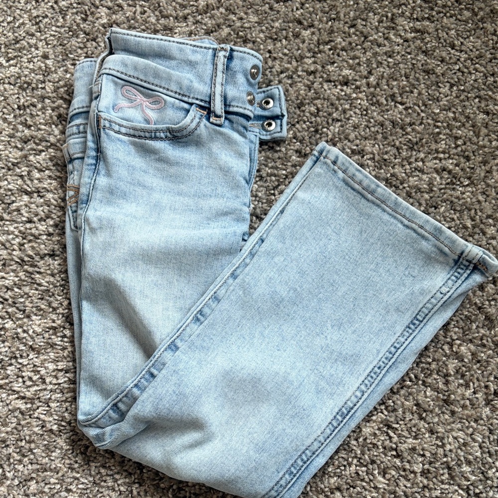 Girls 5/6 bootcut light colored jeans with pink bow detail on pocket